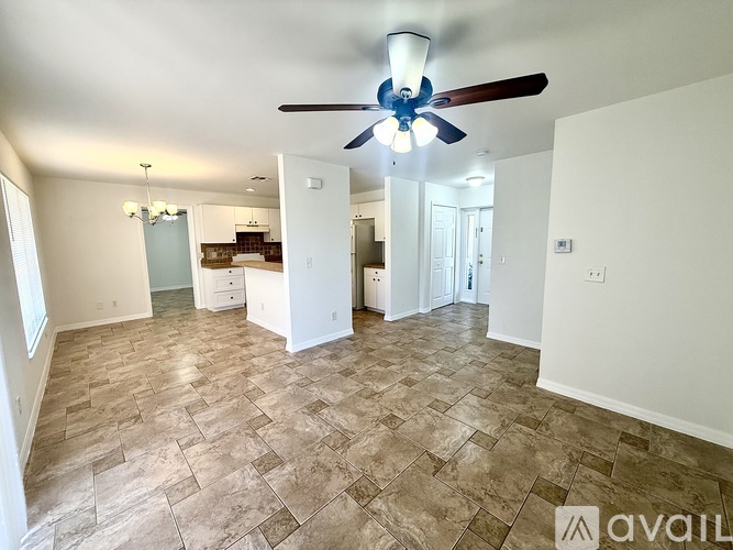 A spacious room with a ceiling fan and tiled flooring.