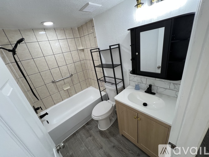 A bathroom with a white tub, toilet, and sink.