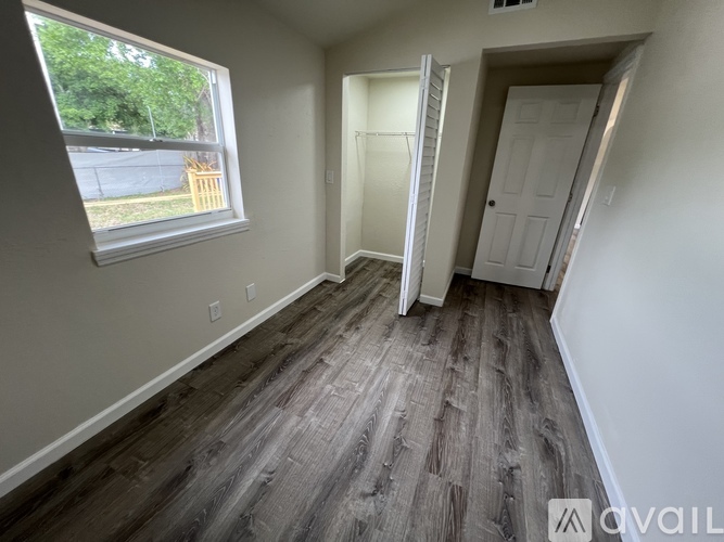 A room with a window and a door is available for rent.