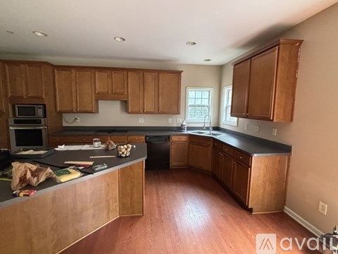 A kitchen with wooden cabinets and a black countertop.