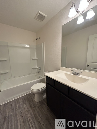 A bathroom with a toilet, sink, and bathtub.