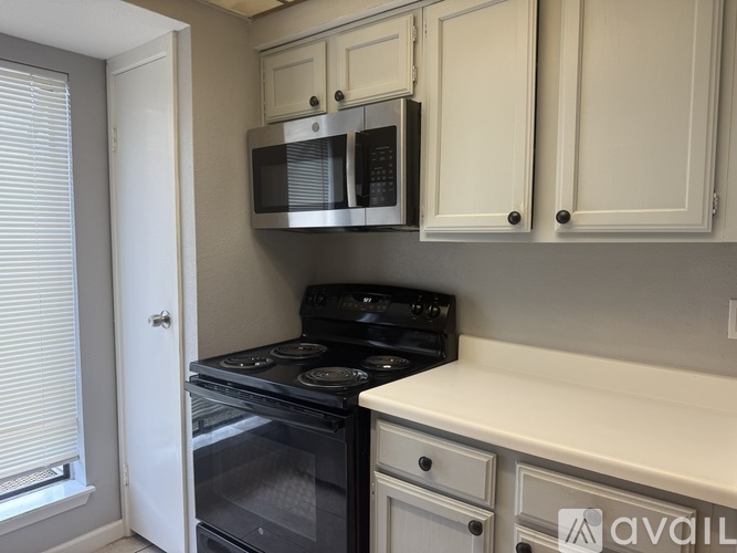 A kitchen with a black stove and white cabinets.