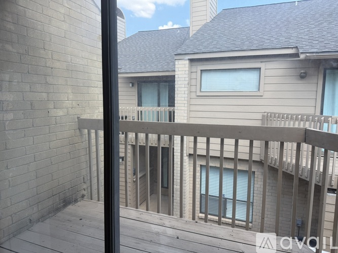 A balcony with a railing and a building in the background.