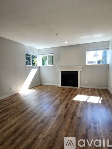 A room with wooden floors and a fireplace is available for rent.