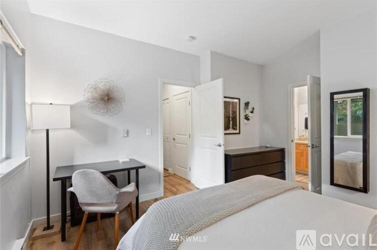 A bedroom with a bed, desk, and chair.