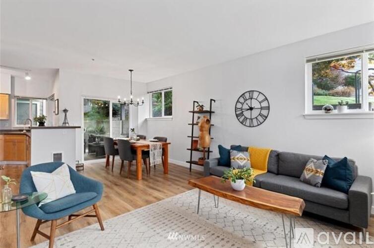 A living room with a grey couch, a blue armchair, and a wooden coffee table.