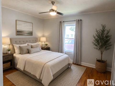 A well-lit bedroom with a large bed and a ceiling fan.