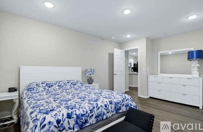 A bedroom with a bed, desk, and chair.