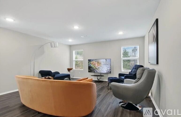 A living room with a large orange sofa and a grey armchair.