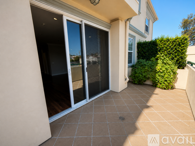 A patio area with a glass door and a tiled floor.