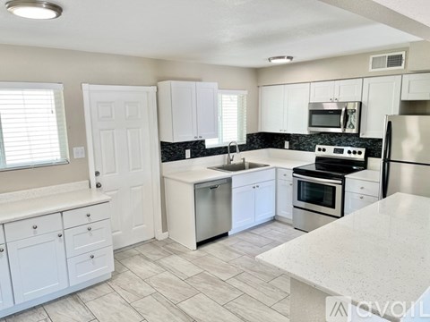 A kitchen with white cabinets and a black stove top oven.