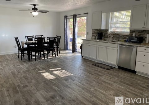A kitchen with a dining table and chairs in the middle of the room.