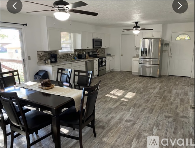 A kitchen with a dining table and chairs.