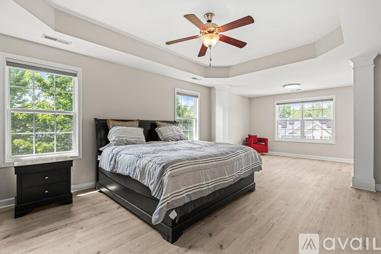A bedroom with a large bed and a ceiling fan.