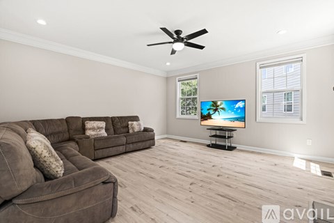 A living room with a brown couch and a flat screen TV.