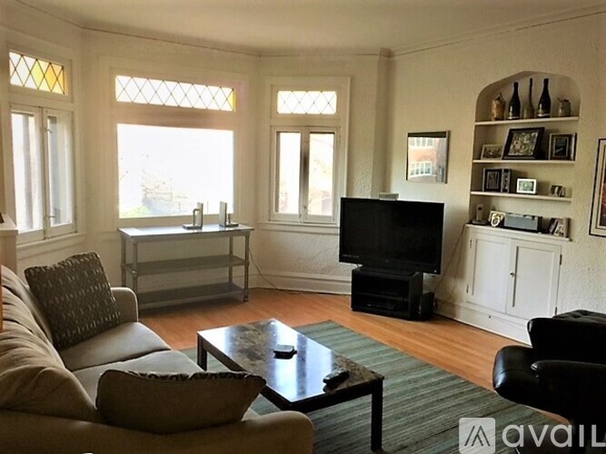A living room with a couch, coffee table, and television.