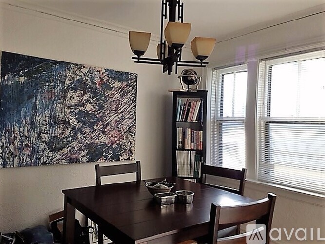 A dining room with a wooden table and chairs.