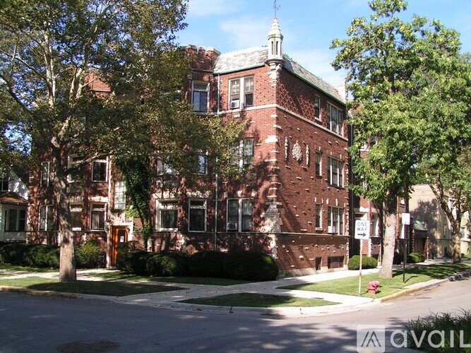 A red brick building with a tower and ivy growing on it.
