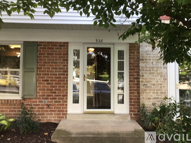 A house with a white door and a brick wall.