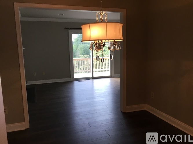 A chandelier hangs over a doorway leading to a deck.