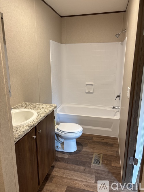 A bathroom with a toilet, sink, and bathtub.