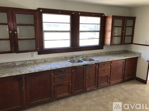 A kitchen with brown cabinets and a granite countertop.