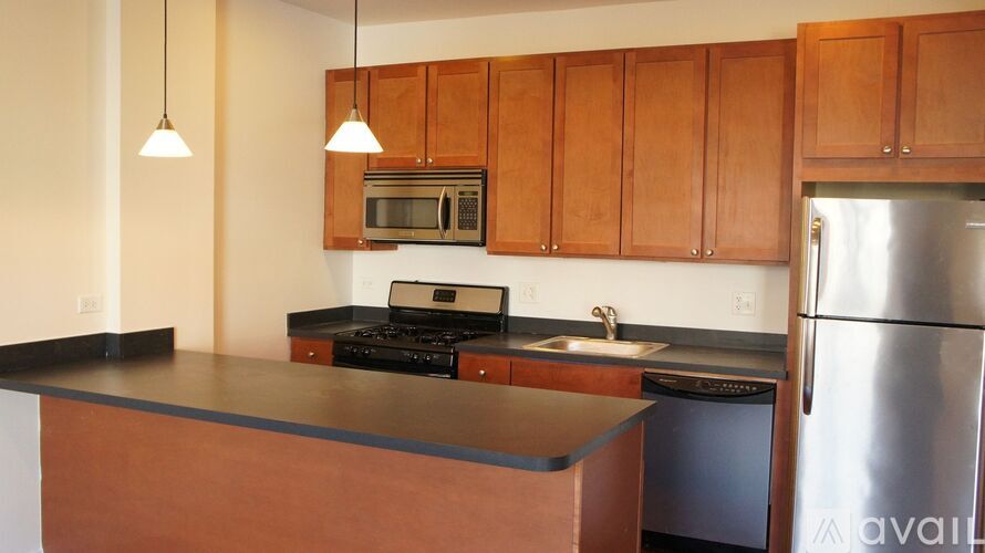 A kitchen with wooden cabinets and a black countertop.