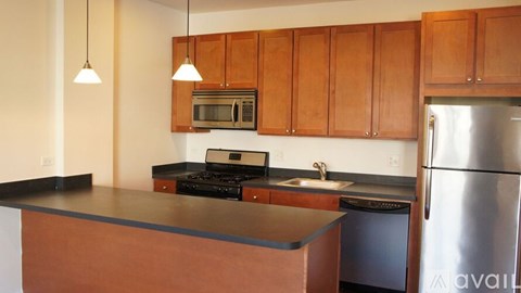 A kitchen with wooden cabinets and a black countertop.