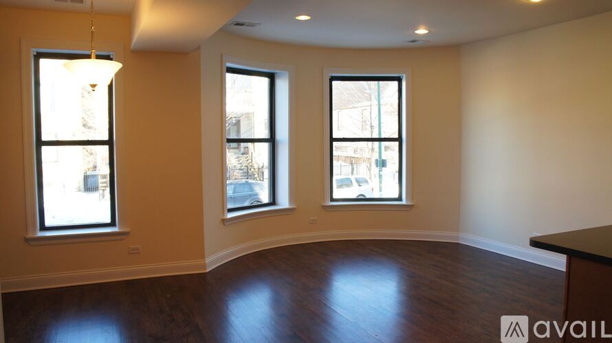 A room with wooden floors and two windows.