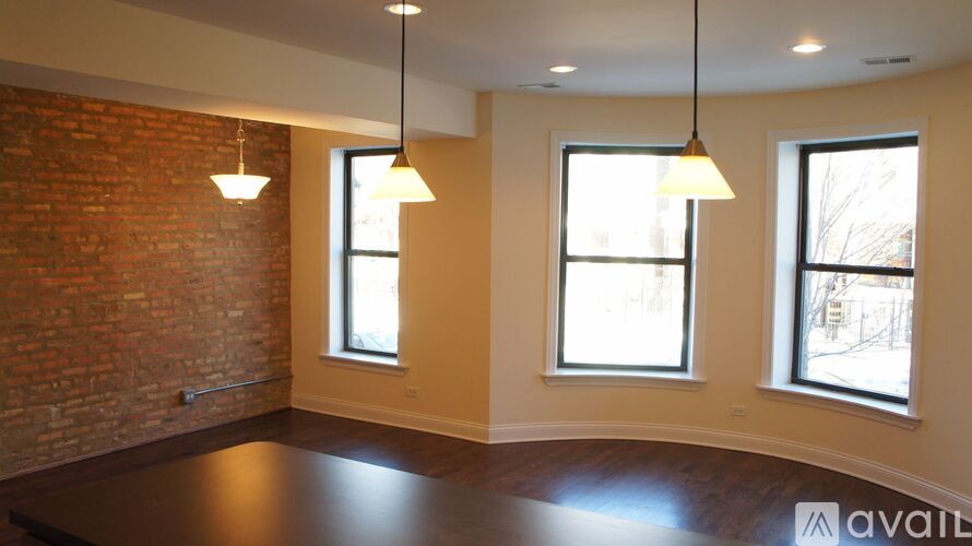 A room with a brick wall and two windows.