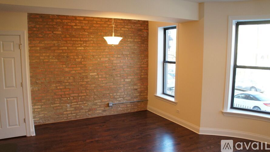 A room with a brick wall and wooden flooring.