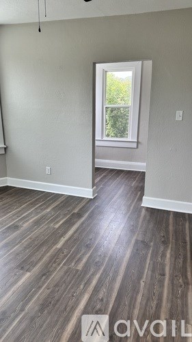 A room with wooden flooring and a window.