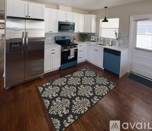 A kitchen with a refrigerator, stove, and sink.