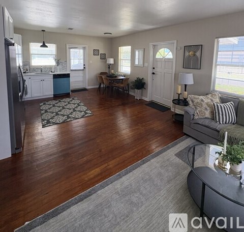 A living room with a grey couch and a wooden floor.