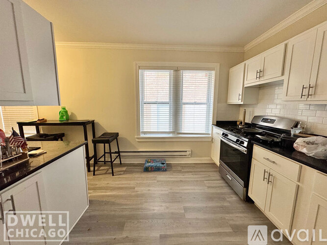 A kitchen with white cabinets and a black stove top oven.