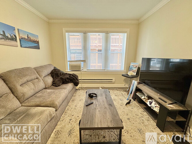 A living room with a couch, coffee table, and television.