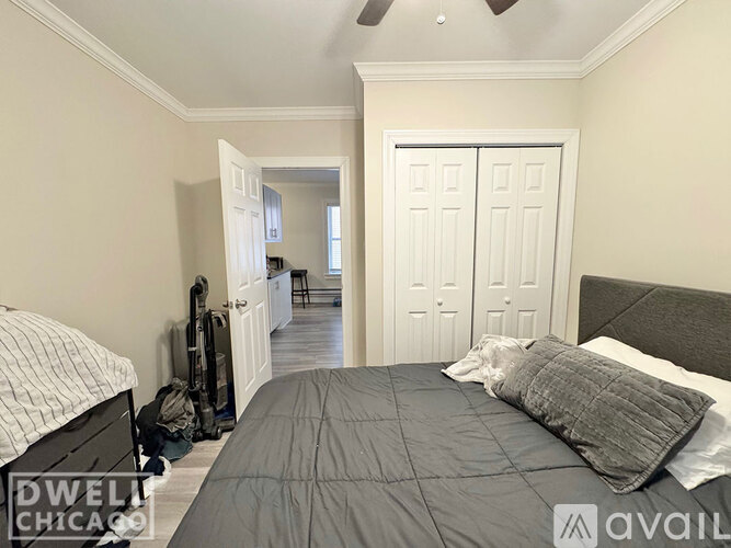 A bedroom with a bed, pillows, and a backpack on the floor.