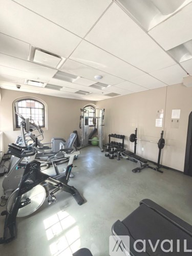 A gym with a row of treadmills and exercise equipment.