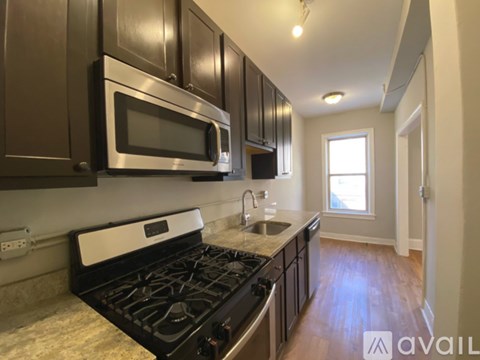 A kitchen with a black stove top oven and a black microwave above it.