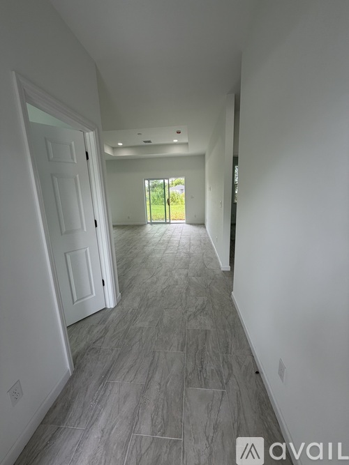 A long hallway with a tiled floor and white walls.