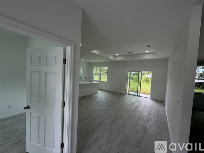A room with a white door and a window with a view of the outside.