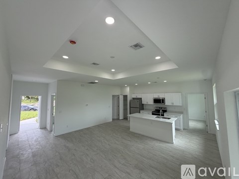 A spacious, well-lit room with a kitchen area and a dining table.