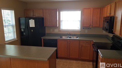 A kitchen with black appliances and wooden cabinets.
