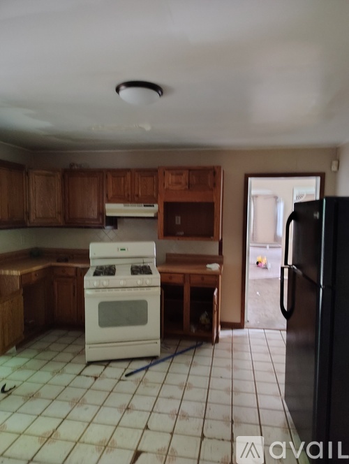 A kitchen with a white stove and a black refrigerator.