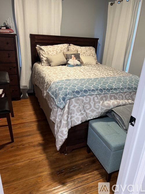 A bedroom with a bed, nightstand, and chair.