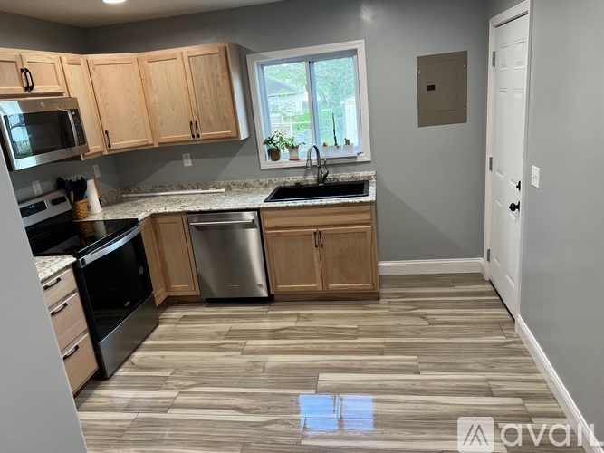 A kitchen with wooden cabinets and a tiled floor.