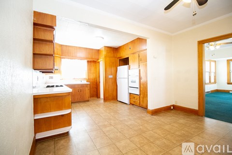 A kitchen with wooden cabinets and a refrigerator.