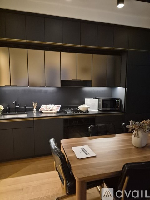 A modern kitchen with a wooden table and chairs in the foreground.