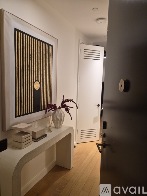 A hallway with a white bench and a painting on the wall.