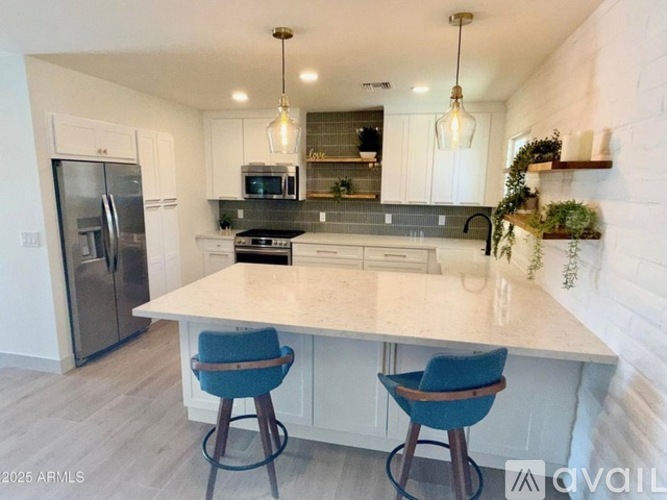 A kitchen with a white countertop and blue chairs.